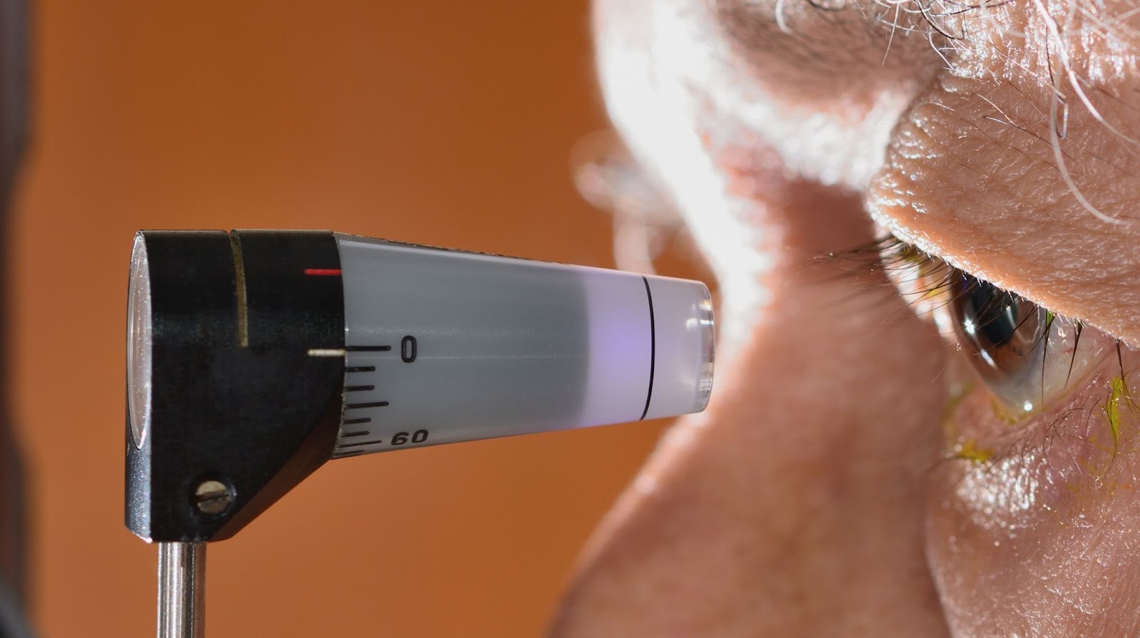 Close-up of an instrument used for a tonometry test next to a patient’s eye. The instrument measures the pressure in the eye.