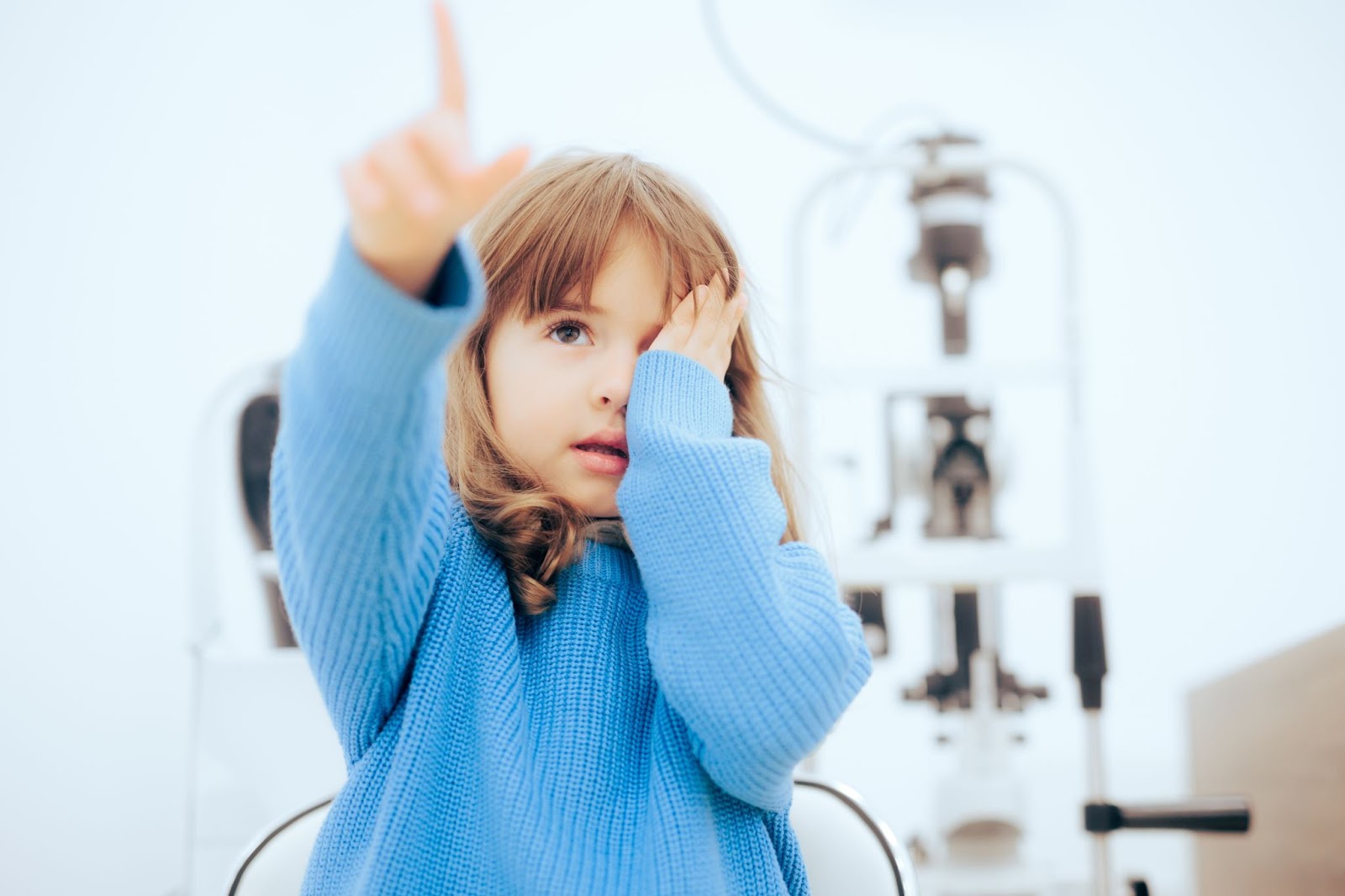 A child is undergoing an eye exam which is covered annually by Sask Health.