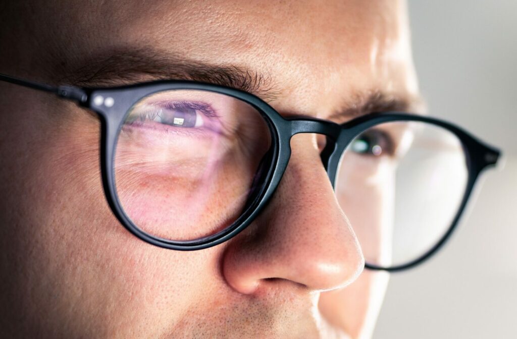 Close up shot of an adults face as they squint through black-framed glasses.