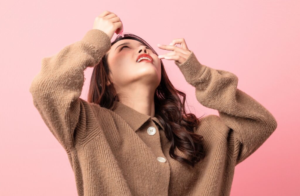 A young woman uses medicated eye drops to handle their conjunctivitis (pink eye).