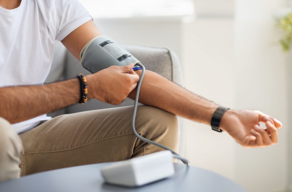 Close-up of a person using an automatic arm blood pressure monitor at home to check their blood pressure.