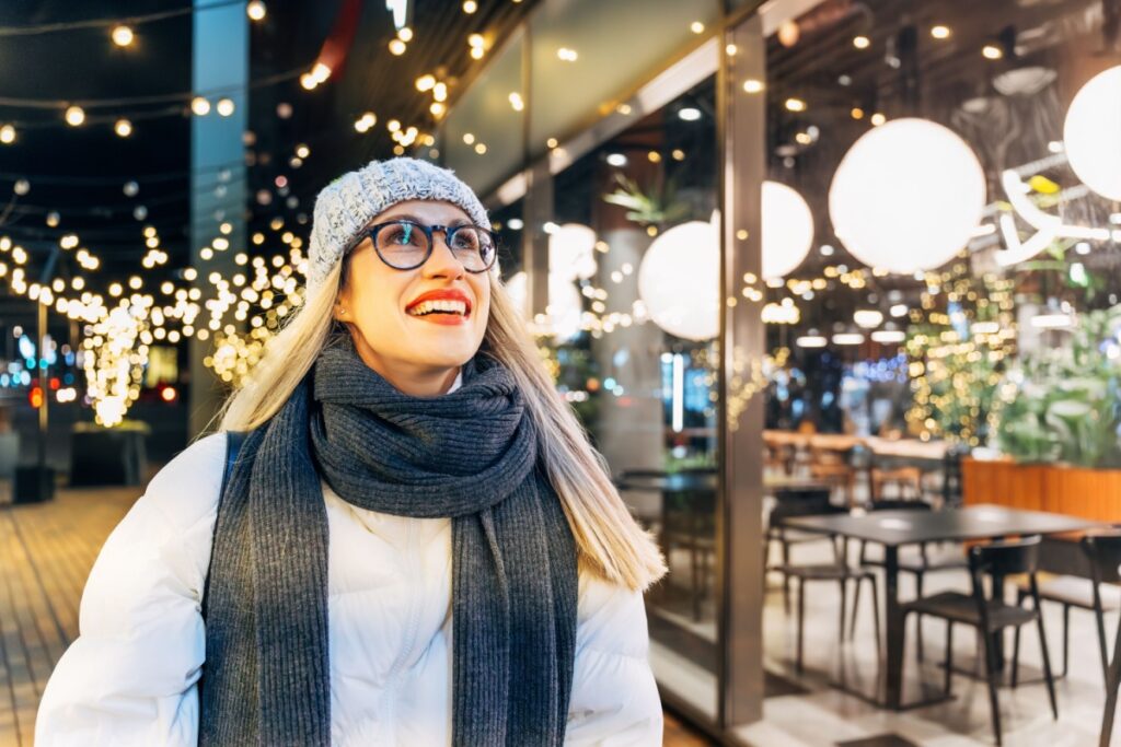 A person wearing glasses with anti-reflective coating looking at Christmas lights.